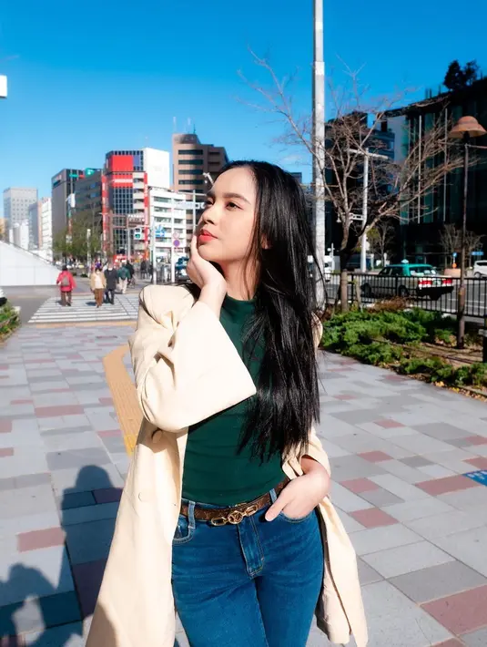 Kaus hijau tampil stylish dengan outerwear warna khakhi dan celana jeans ala Lyodra [@lyodraofficial]