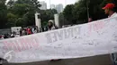 Warga menandatangi spanduk dukungan terhadap pengemudi angkutan berbasis online di kawasan Stadion GBK Jakarta, Minggu (28/8). Selain meminta dukungan tanda tangan warga, mereka melakukan survey kepuasan pelayanan. (Liputan6.com/Helmi Fithriansyah)