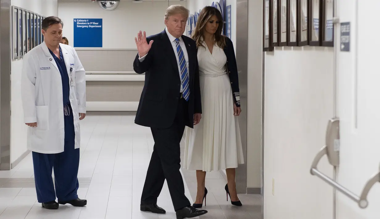 Presiden AS Donald Trump (tengah) saat mengunjungi rumah sakit Broward Health North Pompano Beach, Florida (16/2). Sebelumnya telah terjadi penembakan massal di sebuah sekolah di Florida yang menewaskan 17 orang. (AFP Photo/Jim Watson)