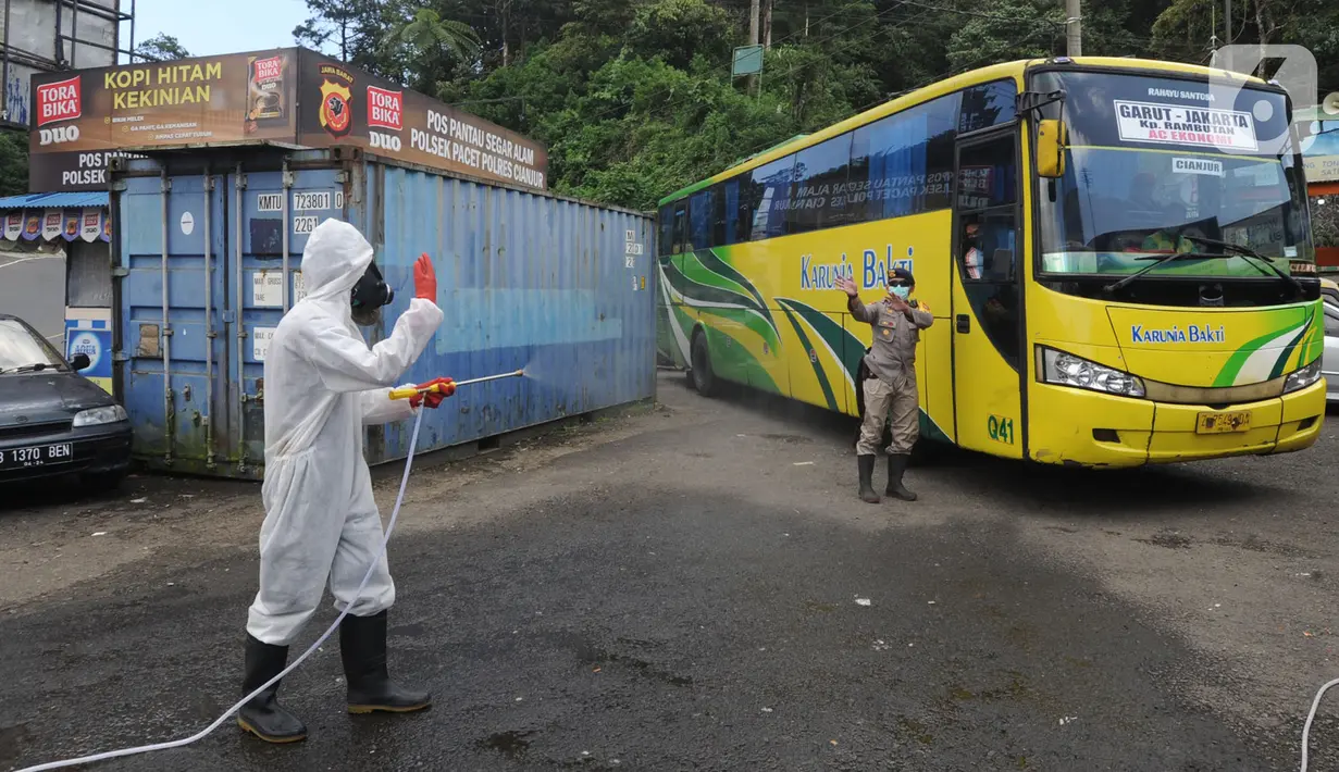 Anggota Batalyon B Brimob Cipanas melakukan penyemprotan disinfektan saat penyekatan arus lalu lintas di kawasan Ciloto, Cianjur, Jawa Barat, Jumat (17/4/2020). Penyemprotan yang dilakukan selama 20 hari tanpa henti ini untuk mencegah penyebaran virus corona COVID-19. (merdeka.com/Arie Basuki)