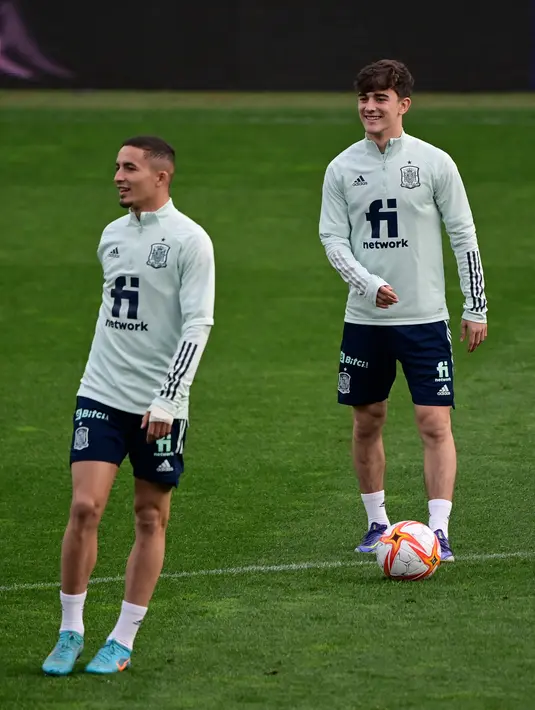 Pemain depan Spanyol Rodrigo (kiri) dan pemain tengah Spanyol Gavi mengambil bagian dalam sesi latihan di La Coruna, Senin (28/3/2022).  Spanyol akan beruji coba melawan Islandia pada pertandingan International Friendly di Stadion Riazor, Rabu 30 Maret 2022 dini hari WIB. (JAVIER SORIANO/AFP)