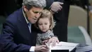 Menteri Luar Negeri AS John Kerry menggendong cucunya Isabelle Dobbs-Higginson saat menandatangani surat Perjanjian Paris tentang perubahan iklim di Markas Besar PBB, Manhattan, New York, AS (22/4). (REUTERS / Carlo Allegri)