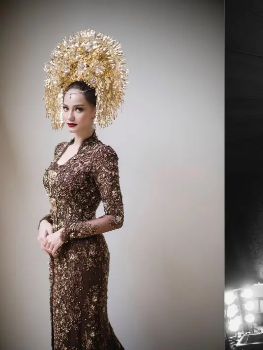 Penampilan luar biasa Enzy Storia menikah mengenakan kebaya. Kebaya panjang berwarna cokelat yang dipenuhi payet emas, membuat penampilan Enzy semakin glamor. [Instagram/enzystoria]