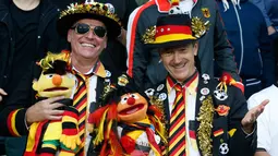 Dua Suporter Jerman menggunakan kostum unik sambil memegang boneka Sasame Street saat mendukung timnya melawan Ukraina pada pertandingan Grup C Euro 2016 di Stade Pierre-Mauroy, Lille, (12/6). (REUTERS/Pascal Rossignol)