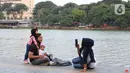 Warga berfoto di area pedestrian Danau Sunter, Jakarta, Sabtu (27/6/2020). Beragam aktivitas dilakukan warga sambil menikmati waktu sore di area Danau Sunter, Jakarta. (Liputan6.com/Helmi Fithriansyah)