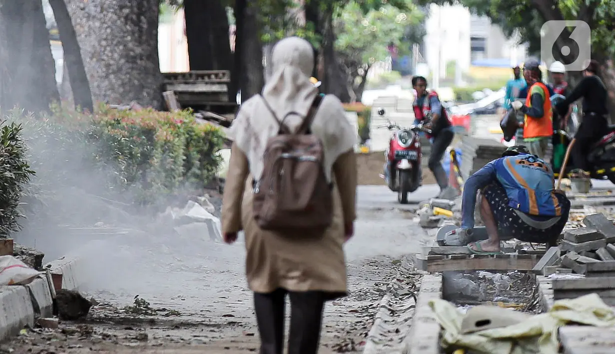 Pekerja menyelesaikan proyek revitalisasi pedestrian di kawasan Jalan Pattimura, Jakarta, Rabu (8/6/2022). Dinas Bina Marga DKI Jakarta merevitalisasi pedestrian dengan memperlebar menjadi tiga meter sehingga cukup luas untuk memberikan kenyamanan para pejalan kaki. (Liputan6.com/Faizal Fanani)