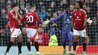 Pemain Manchester United (MU), Harry Maguire, Diogo Dalot, Andre Onana, dan Joshua Zirkzee, tampak lemas setelah gawang tim mereka dibobol Bournemouth dalam laga pekan 17 Premier League 2024/2025 di Old Trafford, Minggu (22/12/2024) malam WIB. MU kalah 0-3 dari Bournmouth di depan para pendukungnya. (Darren Staples / AFP)