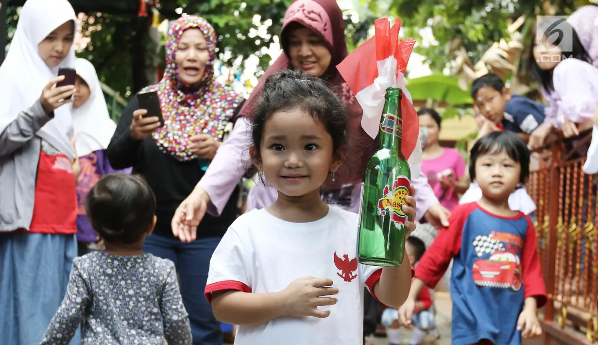 Anak Ayu Ting Ting, Bilqis Khumaira Rozak memegang botol berisi bendera saat mengikuti lomba memindahkan bendera di kawasan Depok, Jawa Barat, Kamis (17/8). Lomba tersebut digelar untuk menyambut HUT ke-72 Kemerdekaan RI. (Liputan6.com/Herman Zakharia)
