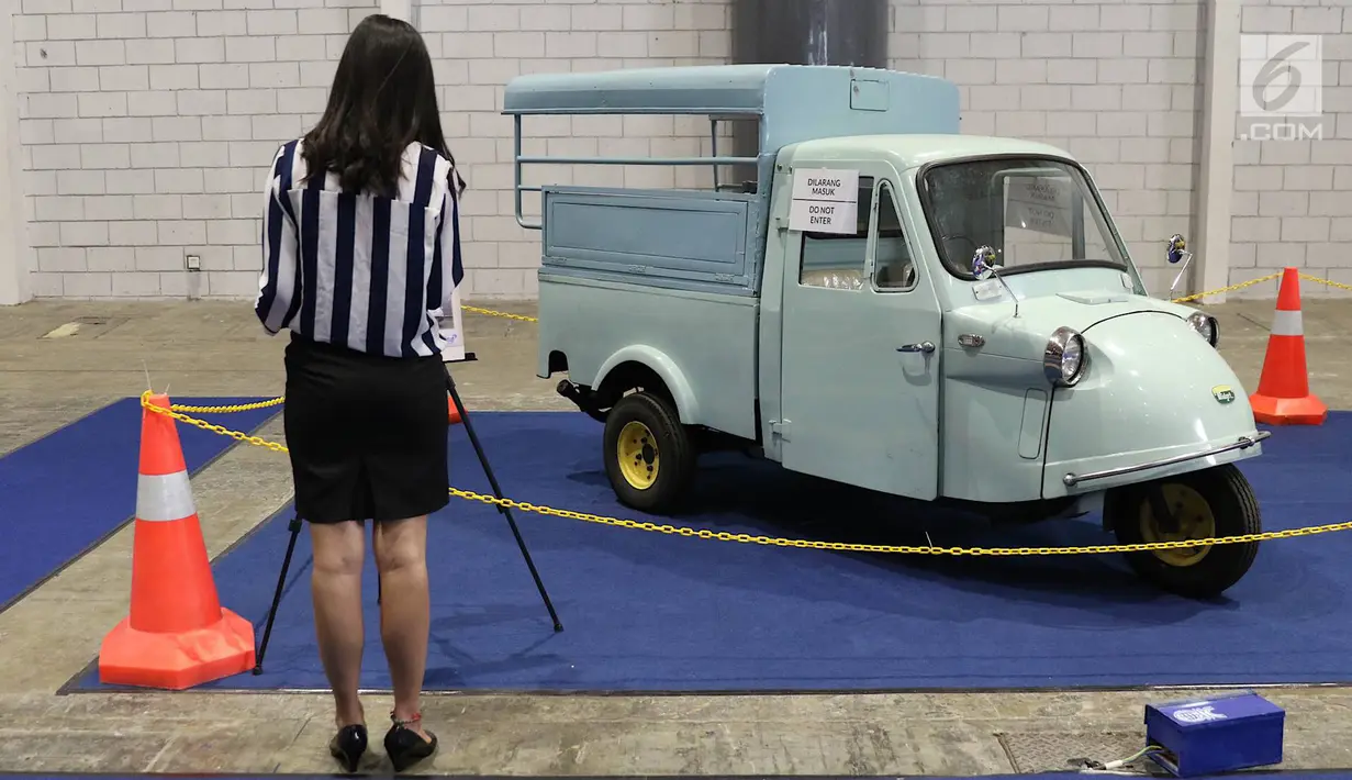 Pengunjung mengamati bemo yang dipajang dalam pameran Indonesia Classic N Unique Bus 2019 di JIExpo Kemayoran, Jakarta, Rabu (20/3). Pameran ini bertajuk ‘Legenda Transportasi Indonesia’. (Liputan6.com/Immanuel Antonius)