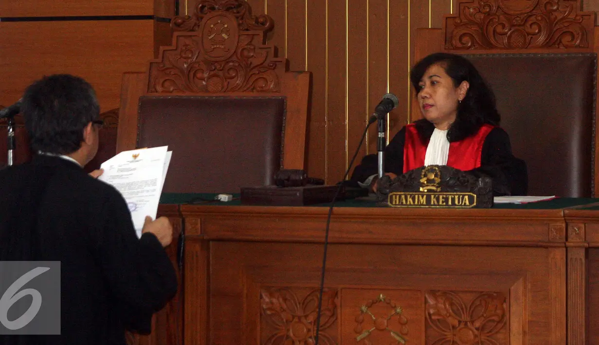 Kuasa hukum RJ Lino, Maqdir Ismail (kiri) menyerahkan surat gugatan praperadilan kepada hakim tunggal Udjiati (kanan) saat sidang praperadilan mantan Direktur Utama Pelindo II RJ Lino di PN Jakarta Selatan, Senin (11/1/2016). (Liputan6.com/Yoppy Renato)