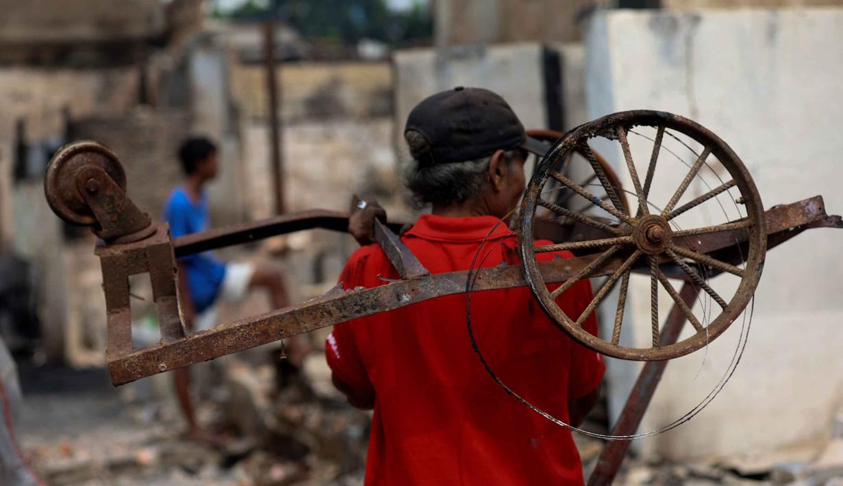 Warga membawa sisa peralatan nan mungkin tetap bisa digunakan alias berbobot di letak jejak kebakaran di permukiman padat masyarakat di Jalan Kemayoran Gempol belakang Pasar Jiung, Kelurahan Kebon Kosong, Kecamatan Kemayoran, Jakarta Pusat, Selasa (2/6/2026). (Kapanlagi.com/Budy Santoso)