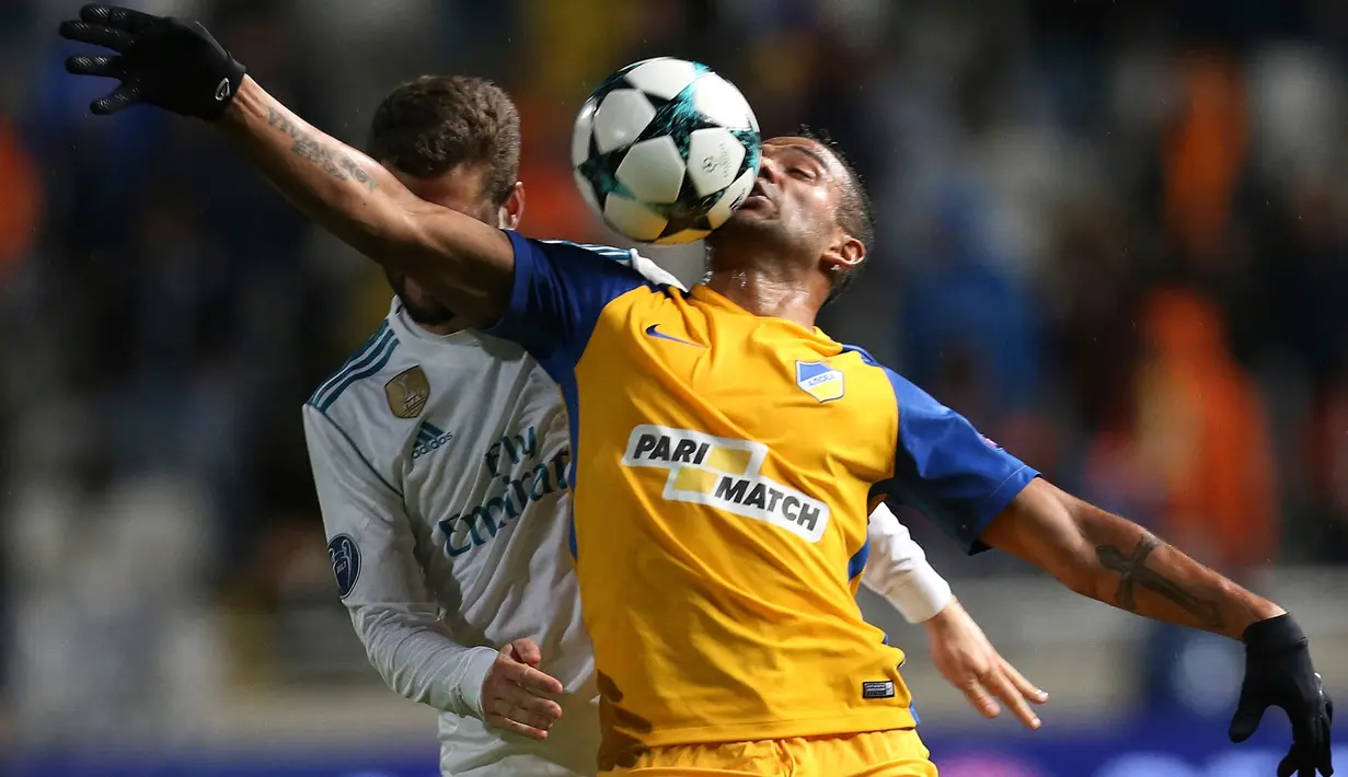 Pemain APOEL Nicosia, Lorenzo Ebecilio (kanan) berebut bola dengan pemain Real Madrid, Nacho pada matchday kelima Liga Champions di Stadion GSP, Selasa (21/11). El Real membukukan kemenangan enam gol tanpa balas. (AP/Petros Karadjias)