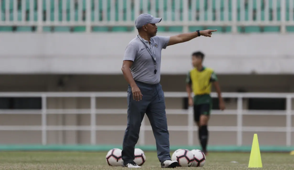 Pelatih Timnas Indonesia U-19, Fakhri Husaini, memberikan instruksi saat latihan di Stadion Pakansari, Bogor, Senin (30/9). Latihan ini merupakan persiapan jelang Piala AFF U-19 di Vietnam. (Bola.com/Vitalis Yogi Trisna)
