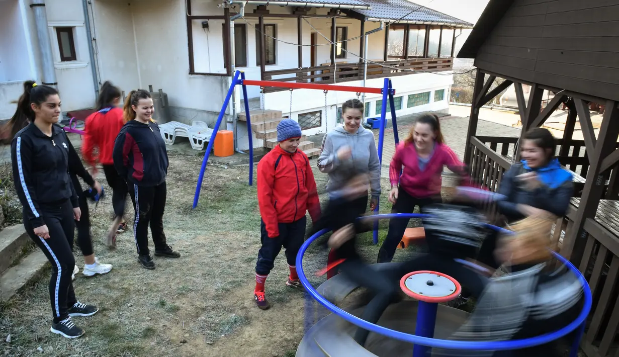 Steluta Duta (tengah) dan rekan-rekan petinju beristirahat setelah sesi pelatihan di sebuah kamp persiapan di Sarata Monteoru, sebuah kota kecil wisata di perbukitan Carpathians Timur di Rumania (14/2/2020). Steluta Duta merupakan gadis yatim piatu yang tinggal di jalanan. (AFP/Daniel Mihailescu)