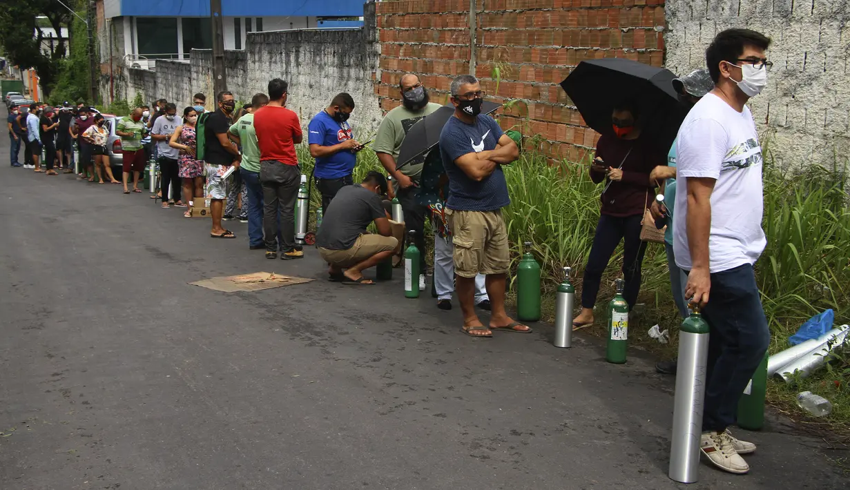 Antrean keluarga pasien COVID-19 yang dirawat di rumah sakit dengan membawa tangki oksigen kosong untuk mengisi kembali di Manaus, negara bagian Amazonas, Brasil, 15 Januari 2021. Negara Bagian Amazonas di Brasil kehabisan oksigen karena semakin melonjaknya pasien Covid-19. (AP Photo/Edmar Barros)
