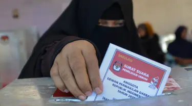 Seorang wanita memasukan kertas suaranya saat latihan pra-pemilihan di Banda Aceh, provinsi Aceh (6/4). Indonesia akan menyelenggarakan Pemilu serentak pada 17 April 2019. (AFP Photo/Chaideer Mahyudin)