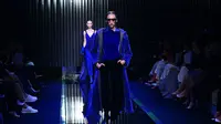 Seorang model memeragakan busana Giorgio Armani untuk koleksi Fall/Winter 2022/2023 pada hari keenam Milan Fashion Week di Milan pada 27 Februari 2022. (MIGUEL MEDINA / AFP)