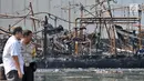 Polisi memantau proses pendinginan kapal yang ludes dilalap api di Pelabuhan Muara Baru, Jakarta, Minggu (24/2). Saat ini belum ada penetapan tersangka karena sejumlah saksi masih diperiksa. (Merdeka.com/Iqbal Nugroho)