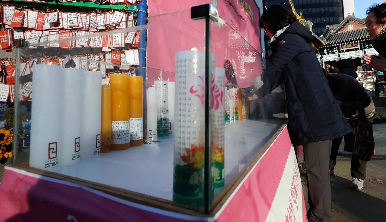 Pengunjung berdoa untuk keberhasilan para siswa dalam ujian masuk perguruan tinggi di kuil Buddha Jogye, Seoul, Kamis (14/11/2019). Ujian masuk perguruan tinggi disebut-sebut sebagai ujian pertaruhan hidup para pelajar Korea Selatan. (AP/Lee Jin-man)
