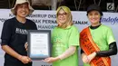 Head of Corporate PR PT Indofood Sukses Makmur Nurulita Novi Arlaida (kedua kanan) dan one Jakarta Utara 2018 Puja Oktaviana (kanan) memberikan cenderamata kepada Nurul Ikhsan di Pesisir Merunda, Jakarta Utara, Sabtu (4/8). (Liputan6.com/HO/Eko)