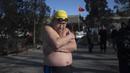 Seorang pria melakukan pemanasan untuk berenang di danau Hou Hai yang beku di Beijing, China (24/1). (AFP Photo/Nicolas Asfouri)