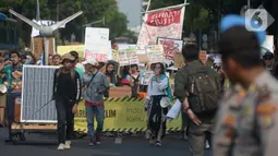 Aktivis lingkungan hidup dari berbagai LSM berjalan kaki menuju Taman Aspirasi di Istana Merdeka, Jakarta, Jumat (29/11/2019). Aktivis meminta pemerintah segera mendeklarasikan perubahan iklim yang semakin kritis. (merdeka.com/Imam Buhori)