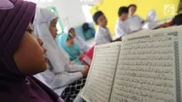 Anak-anak membaca kitab suci Al-Quran di Kampung Quran Alkholidin Cinere,  Depok, Senin (13/5/2019). Momentum bulan Ramadhan 1440 H dimanfaatkan anak-anak usai pulang sekolah untuk membaca dan menghapal Quran secara bersama-sama untuk menambah amalan ibadah puasa. (merdeka.com/Arie Basuki)