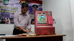 Tiga mesin judi dingdong beserta pemilik dan pelaku pemain judi juga disertakan dalam gelar kasus pencurian dan kekerasan di Polres Jakarta Timur, (8/10/14).(Liputan6.com/Faizal Fanani) 