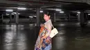 Pilihan layering yang tidak umum ini justru menjadi kekuatan dari penampilannya. Dress batik berpotongan longgar dengan motif penuh warna dan detail pita di bagian dada tampak kontras sekaligus harmonis saat dikenakan di atas kebaya lengan panjang yang lembut dan feminin.  [@amelcarla].