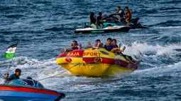 Pantai Lhoknga juga dikenal sebagai spot surfing populer. Tampak dalam foto, orang-orang saat berkumpul menikmati masa libur panjang Idulfitri di area olahraga air, Pantai Lhoknga, Aceh, pada Kamis 26 Maret 2026. (Chaideer MAHYUDDIN/AFP)