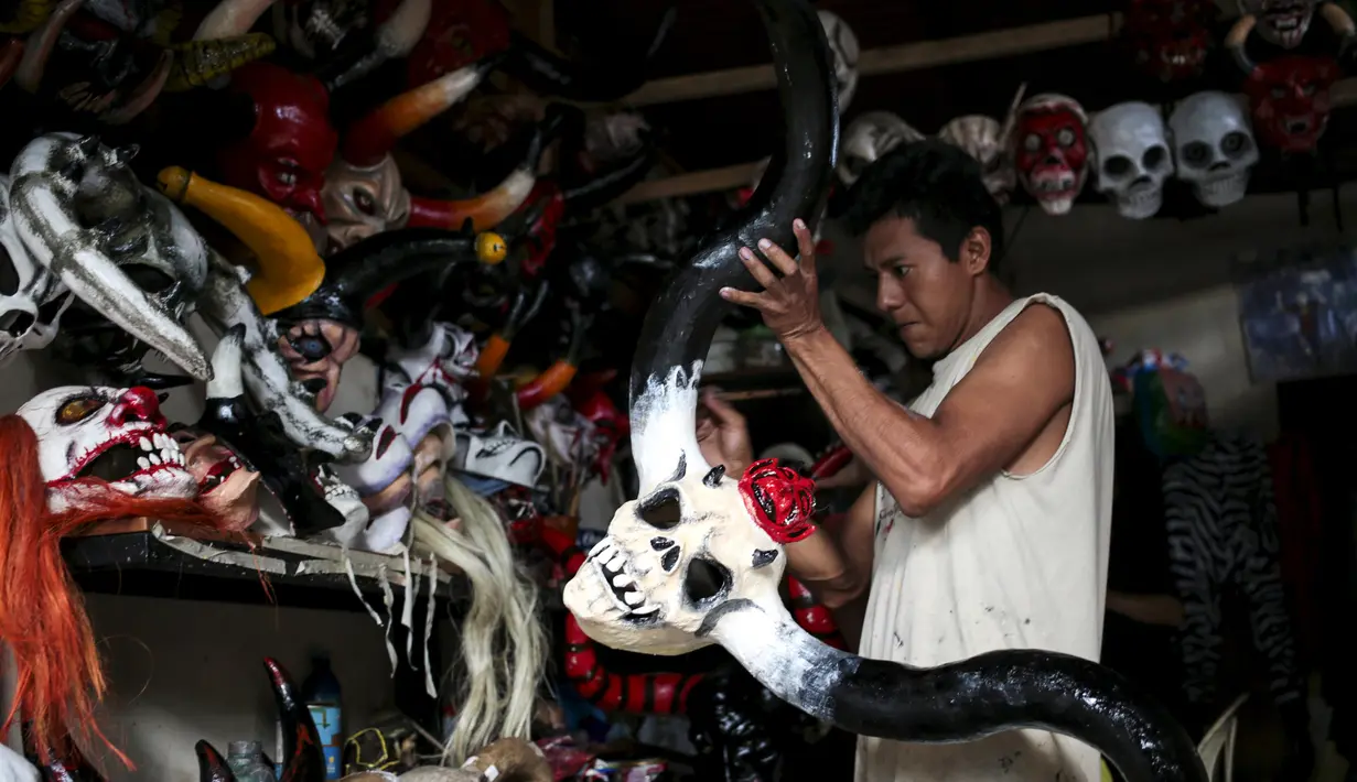 Seorang pria saat mewarnai topeng karakter mitologi Nikaragua dalam persiapan menyambut festival Los Aguizotes, Jumat (18/10/2015).  Festival ini dirayakan setiap tahunnya oleh warga Nikaragua. (REUTERS/Oswaldo Rivas)