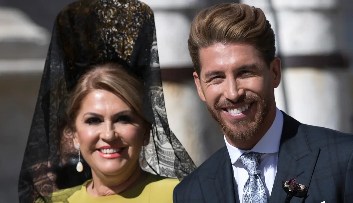 Bek Real Madrid, Sergio Ramos bersama ibunya tersenyum saat tiba di gereja dalam upacara pernikahannya di Sevilla, Spanyol  (15/6/2019). Ramos resmi menikahi kekasihnya Pilar Rubio setelah berpacaran sejak 2012. (AP Photo/Antonio Pizarro)