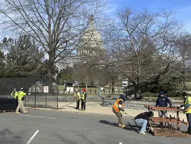 Para pekerja membangun pagar pembatas di sekitar US Capitol, di Washington, Minggu (5/2/2023). Pagar dipasang di sekitar Capitol sebelum pidato kenegaraan atau State of the Union yang akan disampaikan Presiden Joe Biden pada Selasa (7/3) malam waktu AS. (AP Photo/Anna Johnson)