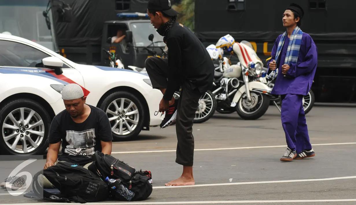 Massa aksi damai melakukan salat di pinggir Jalan Merdeka Barat, Jakarta, Jumat (4/11). Massa melakukan aksi di depan Istana Negara menuntut penegakan hukum kasus dugaan penistaan agama. (Liputan6.com/Helmi Fithriansyah)