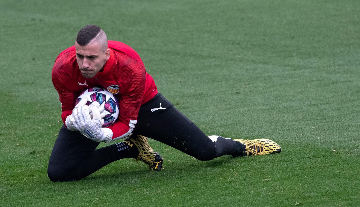 Kiper Valencia Jaume Domenech menangkap bola saat sesi latihan di Paterna Sports City, Paterna, Spanyol, Selasa (18/2/2020). Valencia akan menghadapi Atalanta pada leg pertama babak 16 besar Liga Champions di San Siro, 20 Februari 2020 dini hari WIB. (JOSE JORDAN/AFP)