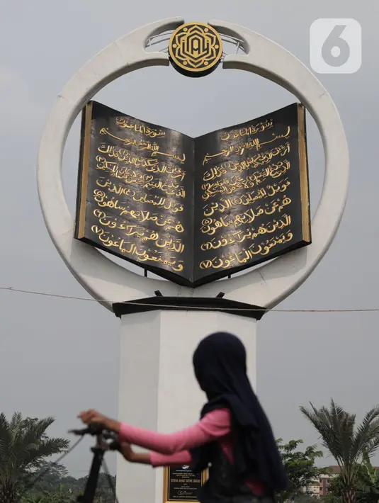 Seorang anak melihat tugu Al-Quran di Masjid Istana Anak Yatim, Desa Cikeas Udik, Gunung Putri, Kabupaten Bogor, Jawa Barat, Jumat (30/4/2021). Tugu Al Quran ini memiliki tinggi 18 meter dan lebar delapan meter. (Liputan6.com/Herman Zakharia)