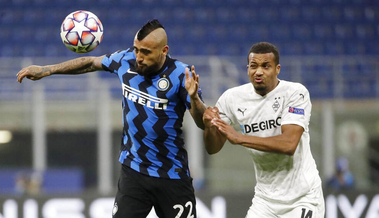 Gelandang Inter Milan, Arturo Vidal, duel udara pemain Borussia Moenchangladbach, Alassane Plea, pada laga Liga Champions di Stadion Giuseppe Meazza, Kamis (22/10/2020). Kedua tim bermain imbang 2-2. (AP/Luca Bruno)