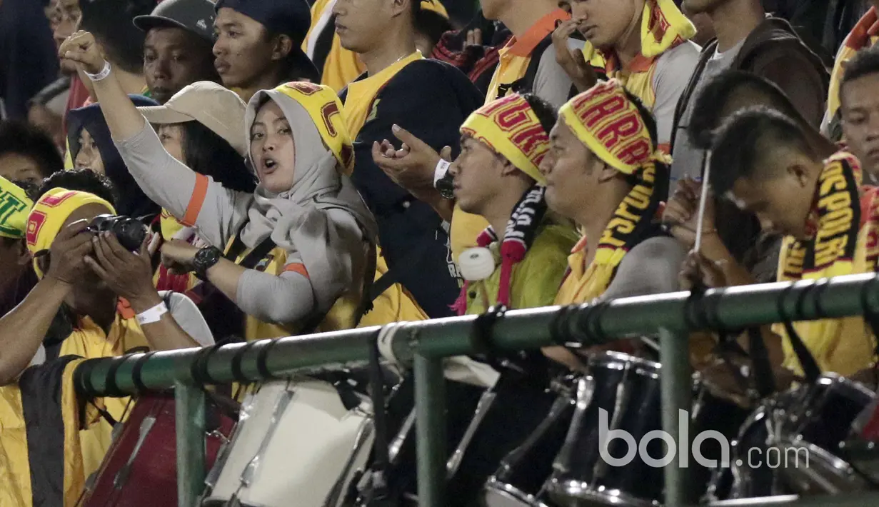 Aksi seorang Polwan bernyanyi mendukung timnya Bhayangkara FC saat melawan Semen Padang pada babak delapan besar Piala Presiden 2017 di Stadion Manahan, Solo, (26/2/2017). (Bola.com/Nicklas Hanoatubun) 