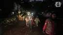 Warga melewati rumah yang tergenang banjir di jalan Bank, Jakarta Selatan, Selasa (4/10/2022). Hujan yang mengguyur wilayah Ibu Kota Jakarta mengakibatkan banjir menggenangi kawasan Kemang, Jakarta. (Liputan6.com/Johan Tallo)