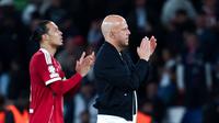 Pelatih Liverpool, Arne Slot, bersama Virgil van Dijk memberikan aplaus setelah laga melawan PSG pada leg pertama perempat final Liga Champions di Parc des Princes, Paris hari Kamis (09/04/2026) dini hari WIB. (AFP/Anne-Christine Poujoulat)