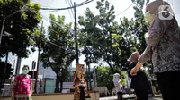Sejumlah pegawai berjemur di bawah sinar matahari di Kawasan Fatmawati, Jakarta, Selasa (31/3/2020). Berjemur diri di bawah sinar matahari saat pagi merupakan salah satu upaya yang paling sederhana untuk menjaga kesehatan selama wabah virus COVID-19. (Liputan6.com/Faizal Fanani)