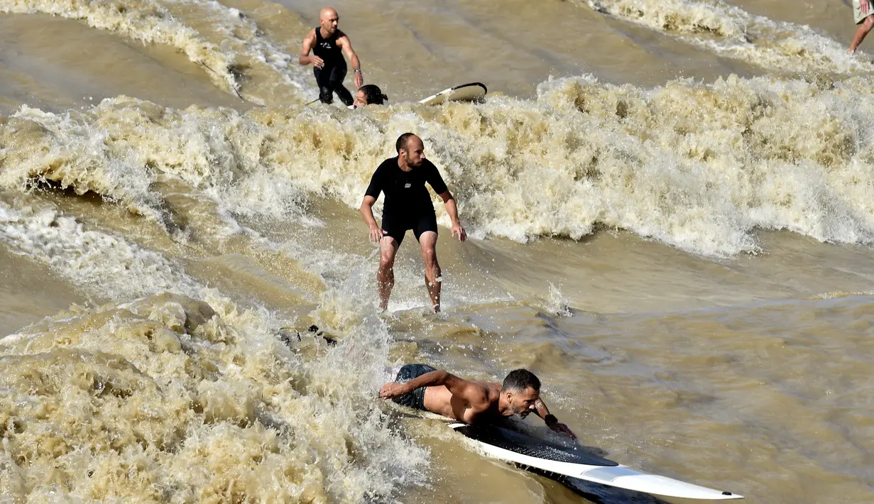 Sejumlah warga saat menikmati bermain surfing di Sungai Dordogne, Saint-Pardon, Prancis (24/7). Fenomena pasang surut besar ini terjadi beberapa kali dalam setahun. (AFP Photo/Georges Gobet)