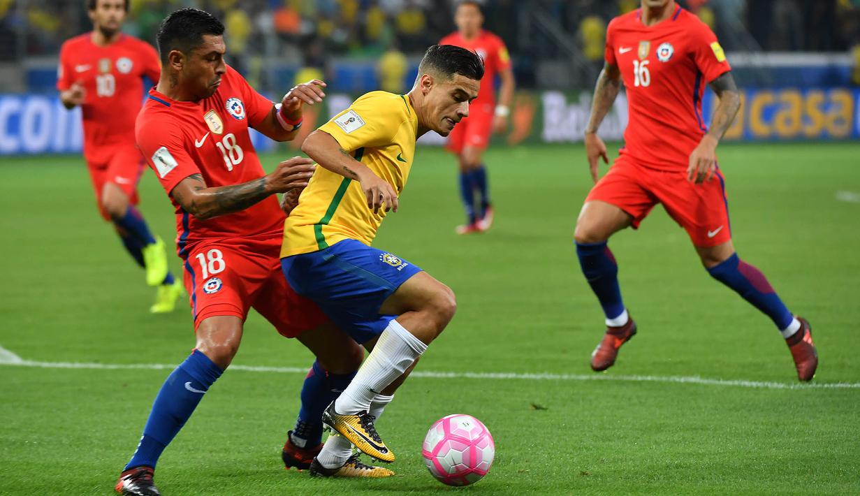 Gelandang Brasil, Philippe Coutinho, berusaha melewati bek Cile, Gonzalo Jara, pada laga kualifikasi Piala Dunia 2018 di Stadion Allianz Parque, Sao Paulo, Selasa (10/10/2017). Brasil menang 3-0 atas Cile. (AFP/Nelson Almeida)