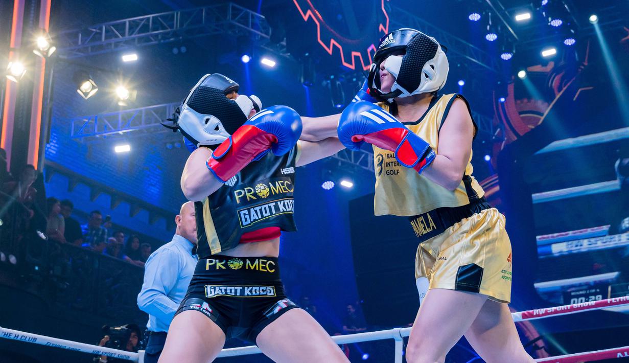 Disjoki, Dinar Candy (kiri), bertanding secara kompetitif dengan penyanyi dangdut, Pamela Safitri (kanan), dalam pertandingan tinju antar selebriti Holywings Sport Show (HSS) Series 3 yang berlangsung di Atlas Super Club, Bali, Minggu (10/9/2023). (Dok. Holywings)