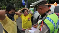 Polisi terpaksa menilang beberapa peserta kampanye Partai Golkar yang tidak mengenakan helm (Liputan6.com/Andrian M Tunay)