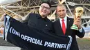 Peniru Presiden Rusia, Vladimir Putin dan pemimpin Korea Utara, Kim Jong-un berpose dengan replika piala Piala Dunia usai penyisihan Grup A antara Uruguay vs Rusia di Samara Arena, Senin (25/6). Uruguay berhasil melumat Rusia 3-0. (AFP/EMMANUEL DUNAND)
