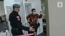 Pengunjung keluar dari ruang disinfeksi  yang disiapkan di pintu masuk menuju kompleks Istana, Jakarta, Senin (16/3/2020). Pihak Istana Kepresidenan menyediakan ruang disinfeksi berbentuk kubus berwarna putih untuk mendeteksi tamunya yang terjangkit virus corona Covid-19 (Liputan6.com/Faizal Fanani)