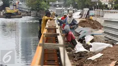  Para pekerja menyelesaikan pembangunan turap di sepanjang Kali Grogol, Jakarta, Senin (21/11). Pembangunan turap dilakukan untuk mencegah meluapnya air kali saat hujan dan ditargetkan selesai 20 Desember 2016. (Liputan6.com/Gempur M Surya)