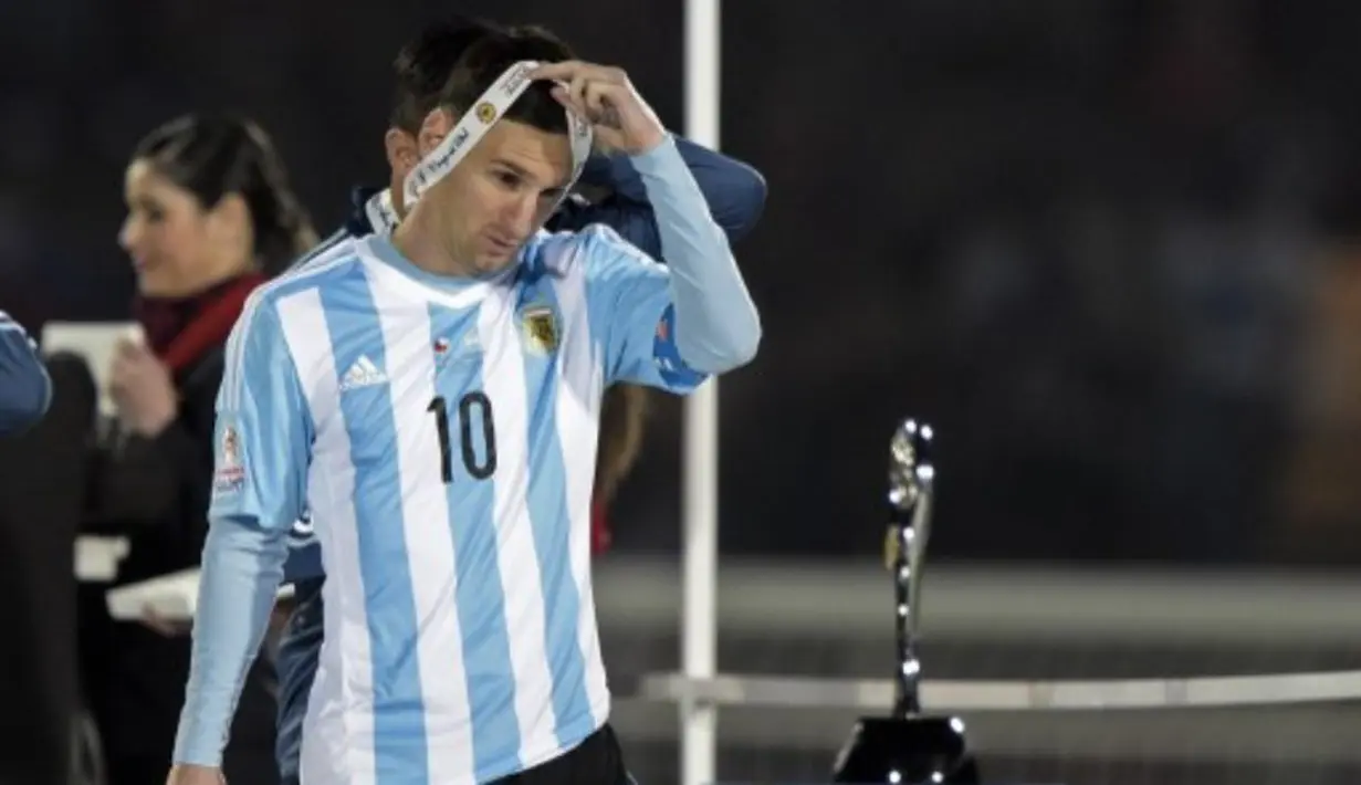 Lionel Messi melepas medali perak yang diraihnya. (AFP PHOTO/JUAN MABROMATA)