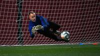 Kiper Barcelona, Marc-Andre Ter Stegen berusaha menangkap bola saat mengikuti sesi latihan tim di Joan Gamper Sports City di Sant Joan Despi (17/12/2019). Barcelona akan bertanding melawan Real Madrid dalam laga El Clasico di Camp Nou. (AFP/Lluis Gene)